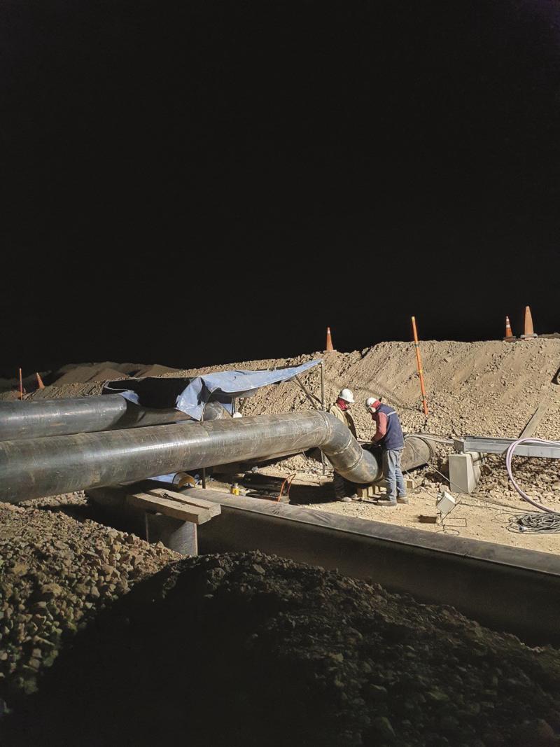 Montaje nocturno de una línea de cañería en obra